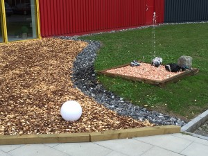 Ein Brunnen mit rötlichen gerundeten Steinen